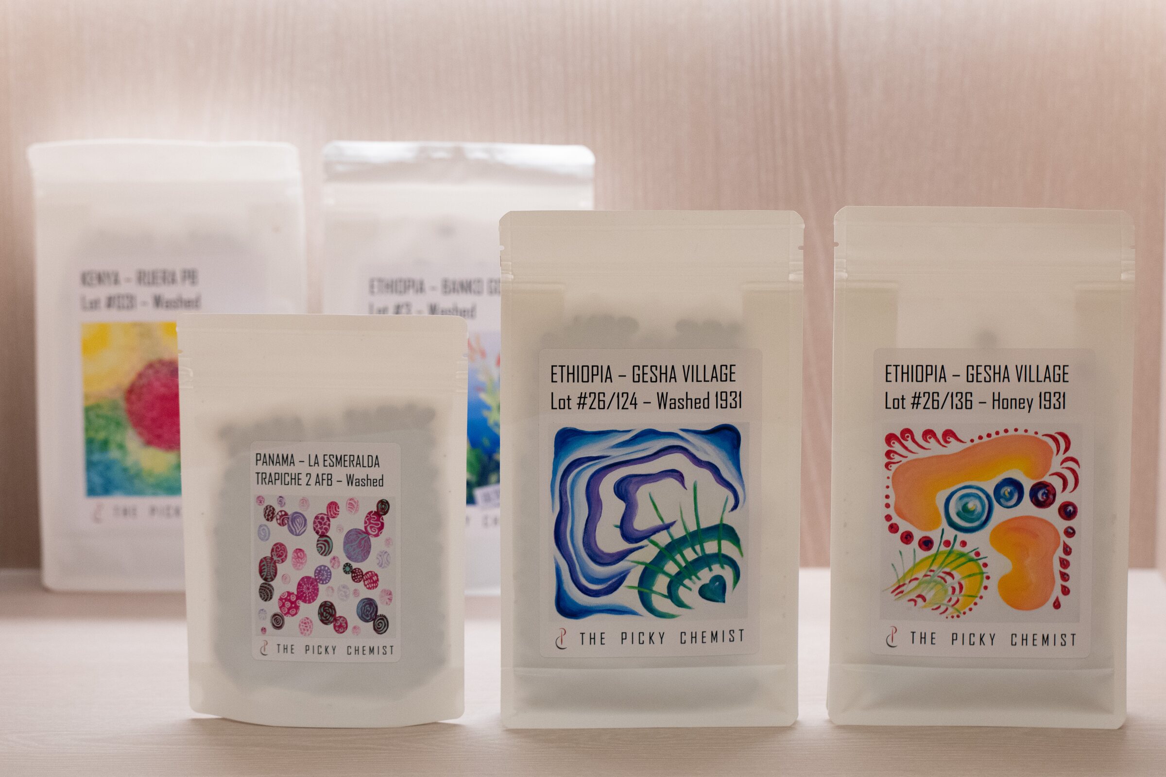 The three Lightmist Drop 007 coffees from The Picky Chemist, with two additional TPC release bags behind them